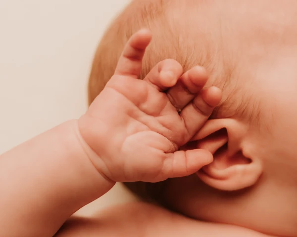 Closeup on newborn's hand and ear in Kamelia's studio