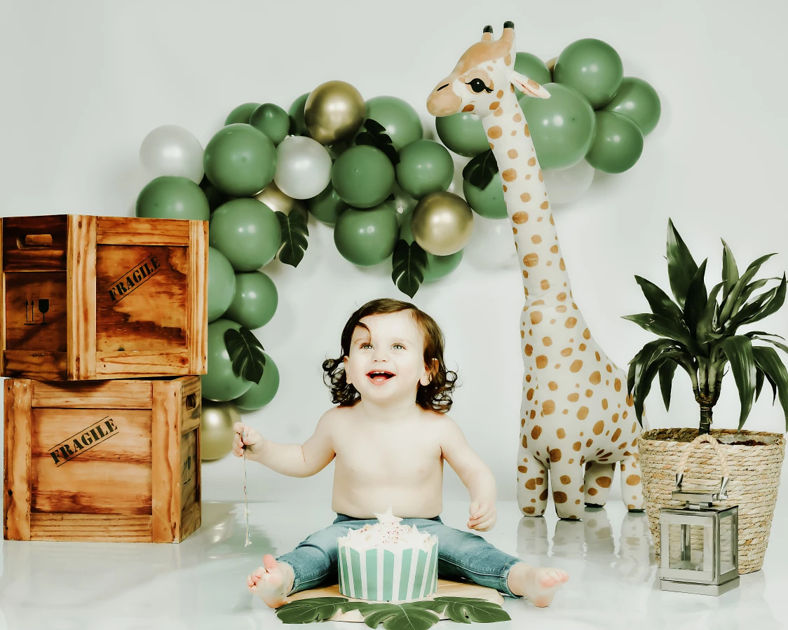 Smiling baby in a jungle cake smash setup